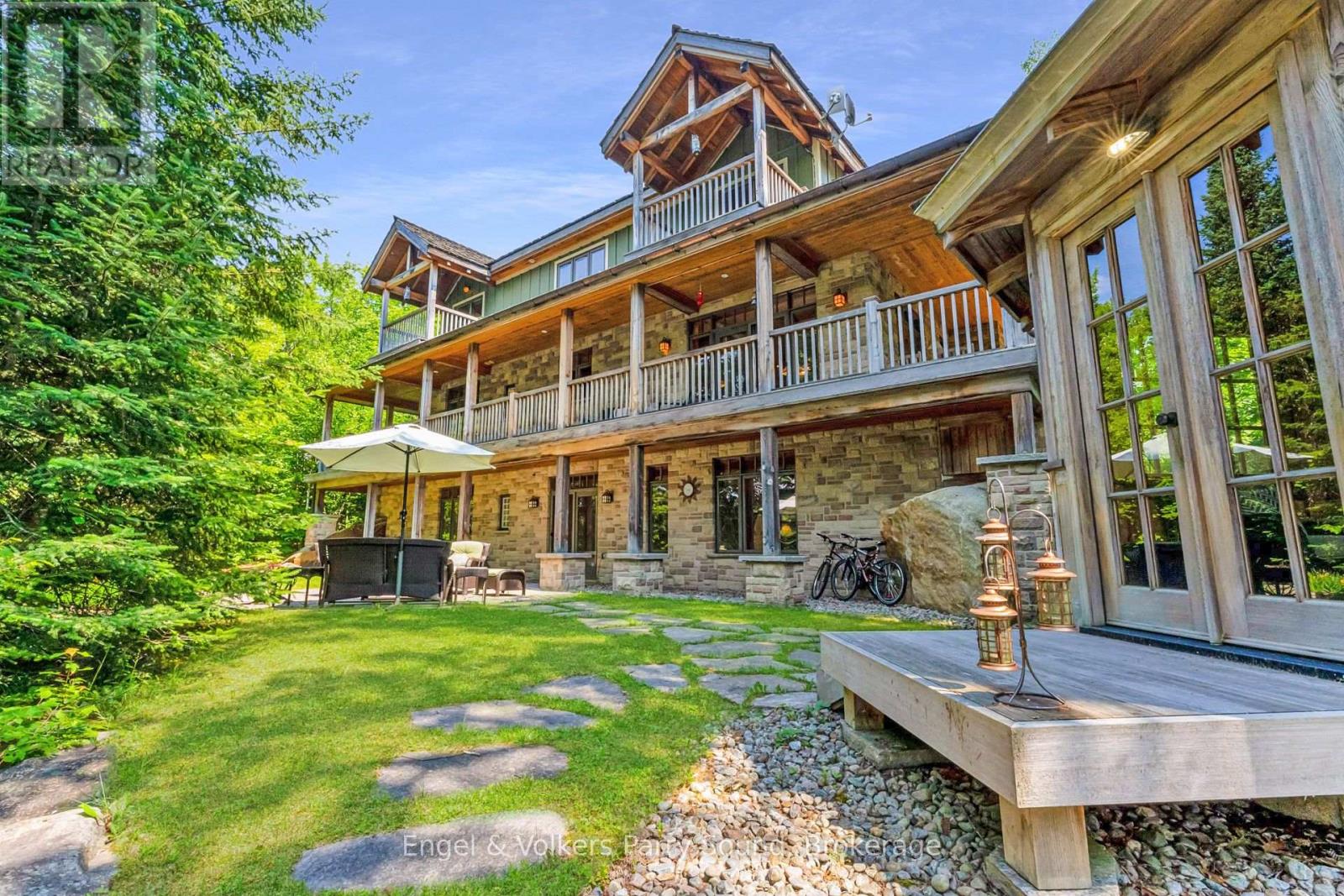 The lakehouse exterior with cedar shingles, stonework and covered decks