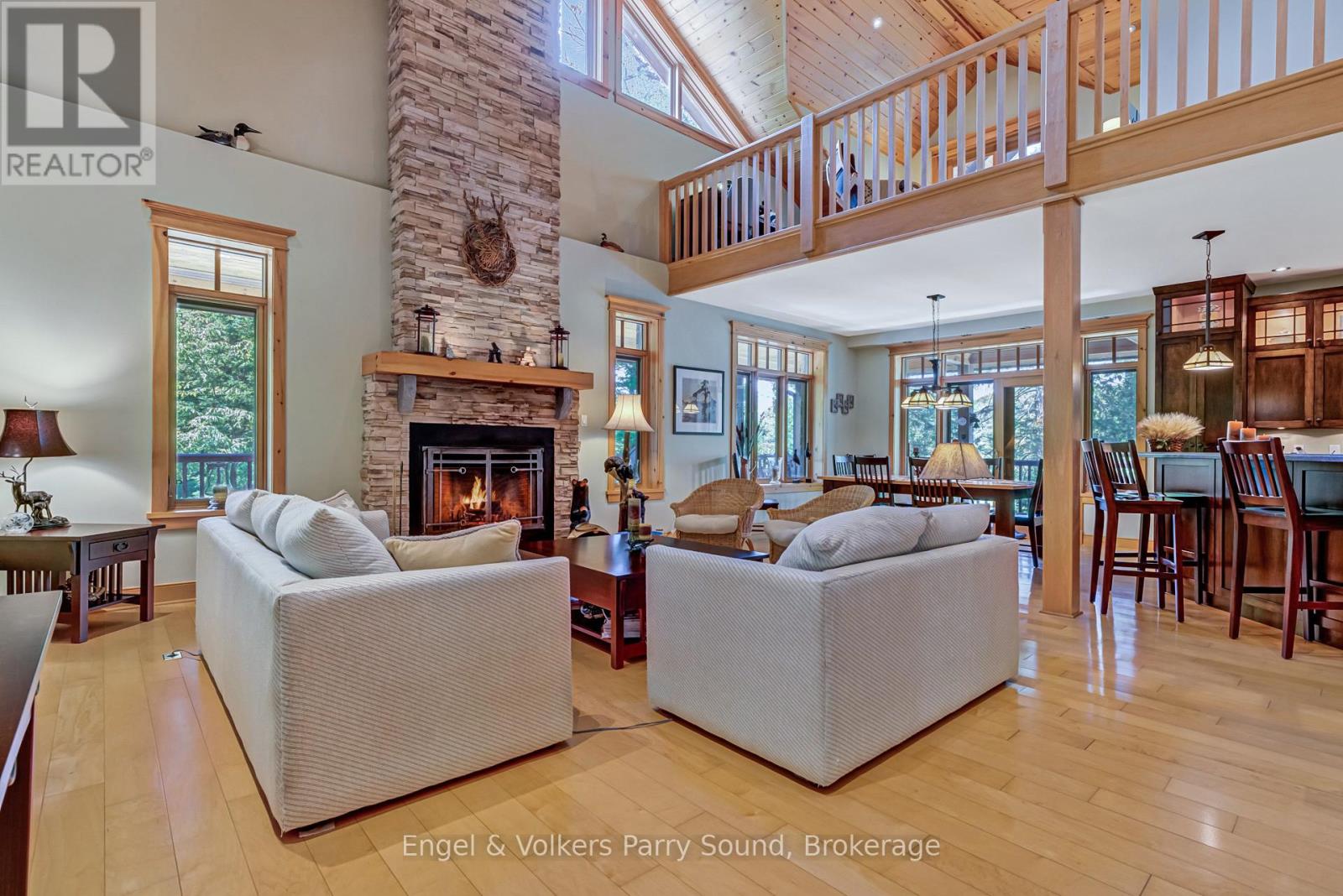Great room with stone fireplace and lake-facing windows